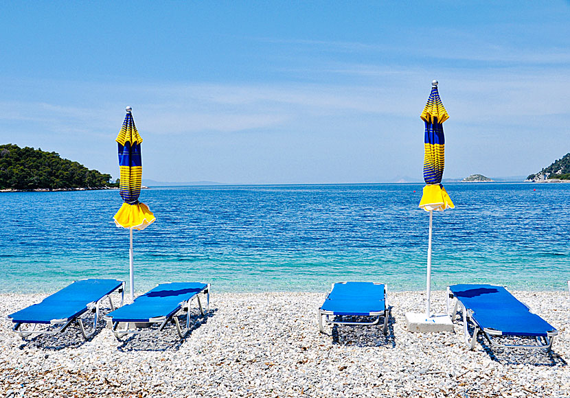 The sunbeds and parasols on the beach in Panormos are yellow and blue.