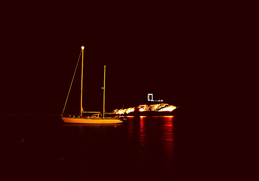 A sailboat in the sea outside the Portara in Naxos town in the evening.