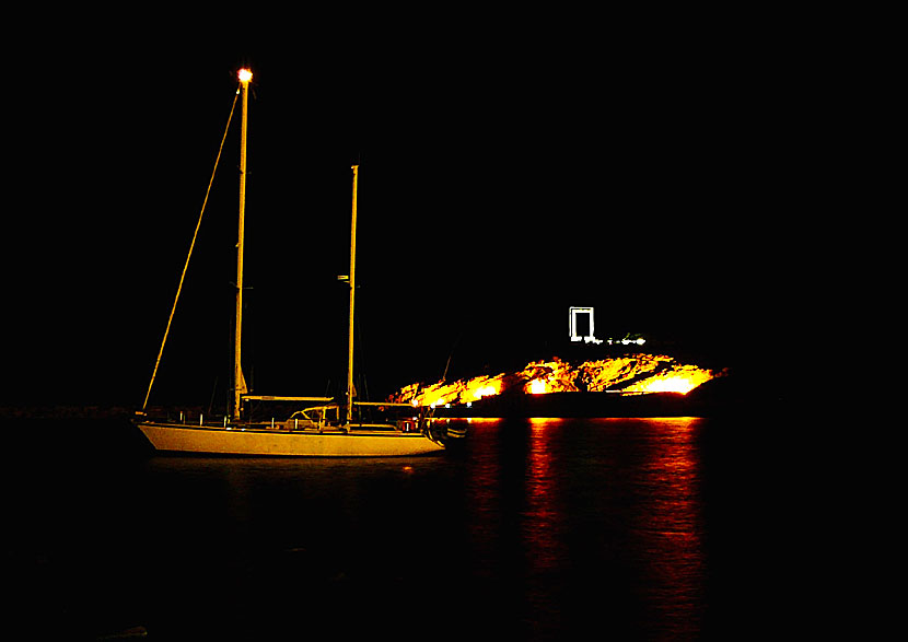 Palatia island and Portara in Naxos are illuminated in the evening.